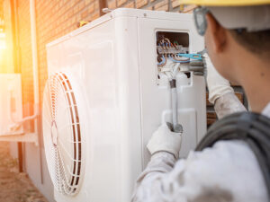 hvac technician repairing ductless air conditioner at property exteriors kentwood mi